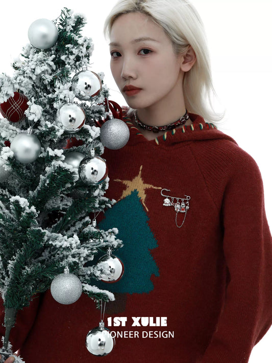 Model wearing a festive sweater featuring a cute puppy brooch pin against a decorated Christmas tree