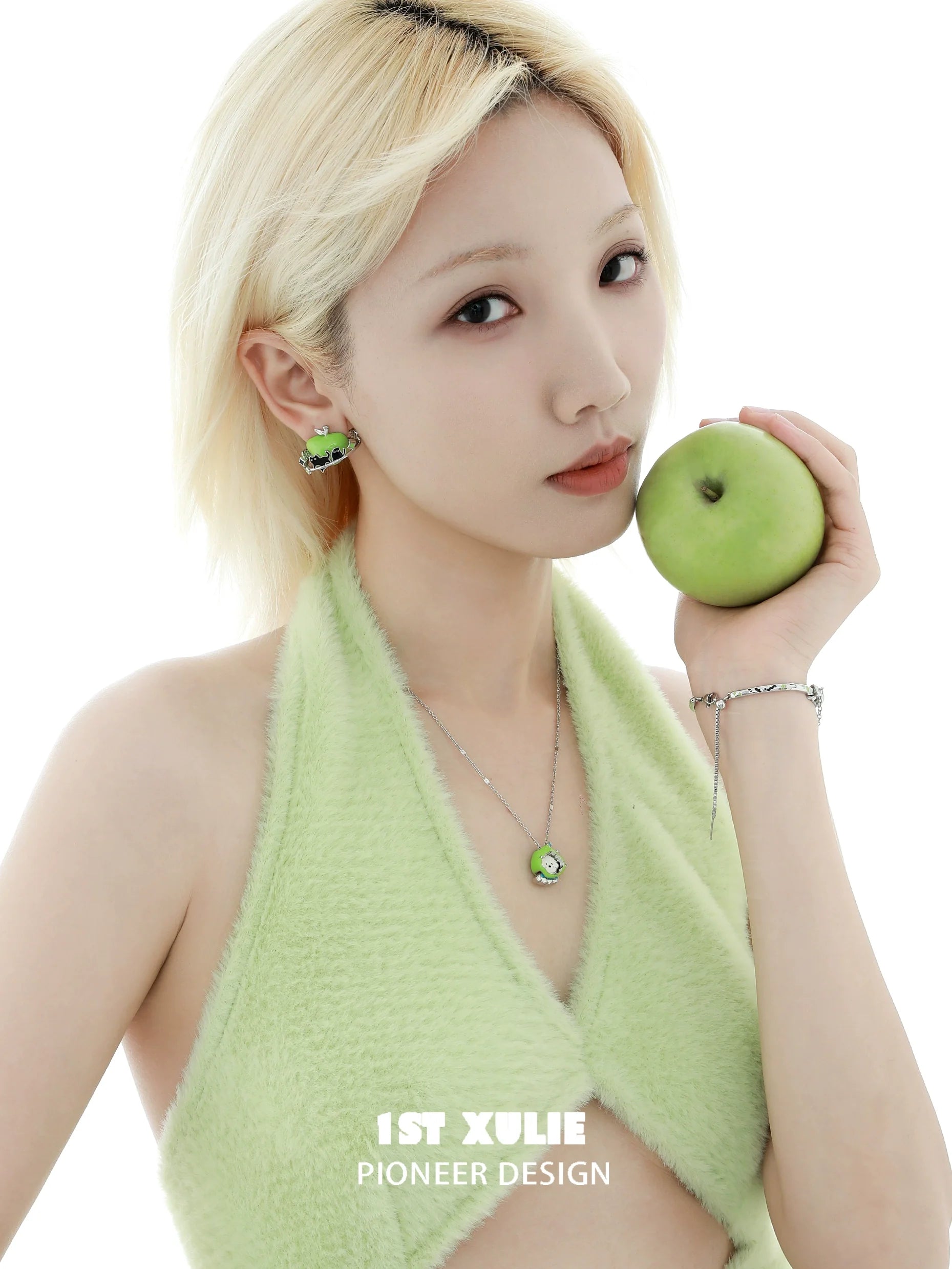 Model wearing a cute puppy pendant necklace, holding a green apple, showcasing stylish jewelry design
