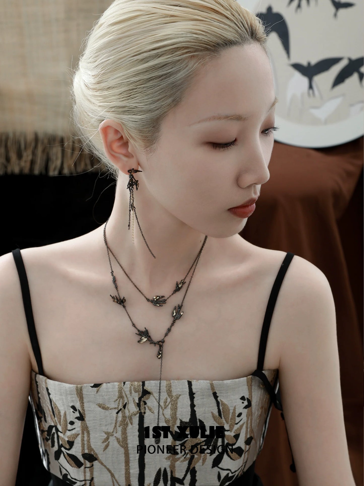 Model wearing a dark swallow necklace with delicate design, showcasing layered strands and intricate details
