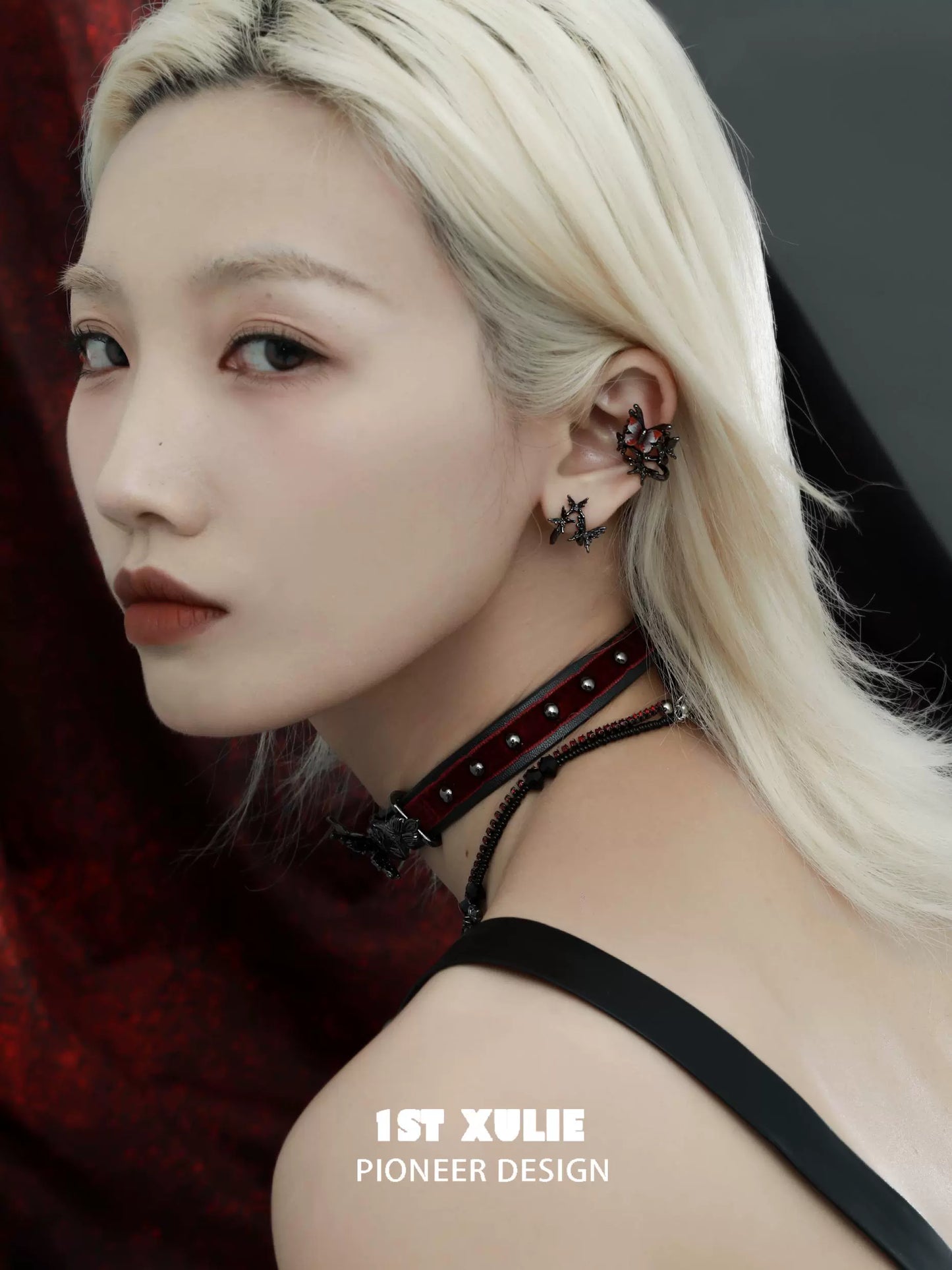 Dark thorn butterfly earrings from 1STXULIE displayed on a model with a dramatic hairstyle