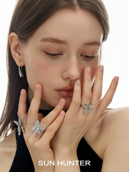 Model wearing SUN HUNTER double-layer butterfly ring alongside other butterfly-themed jewelry