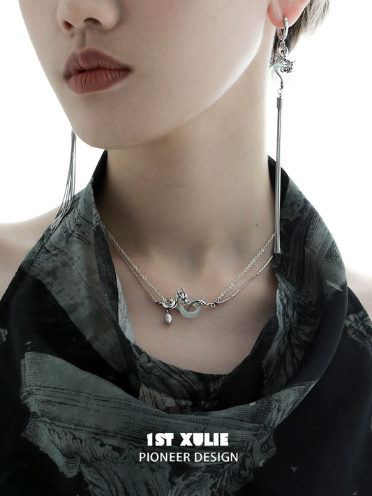 Elegant model showcasing a dragon silver necklace layered with delicate chains and unique charm detail