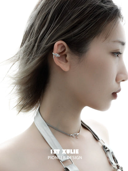 Stylish edgy heart ear cuff in silver worn on a model's ear, showcasing unique design and artistry