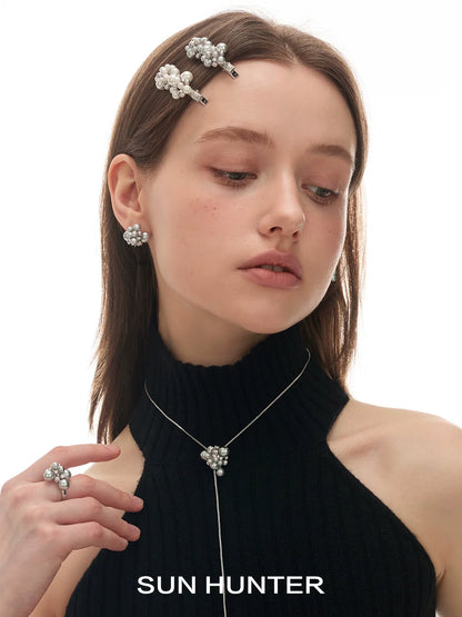 Elegant pearl statement ring worn by a model with matching pearl accessories and a black top