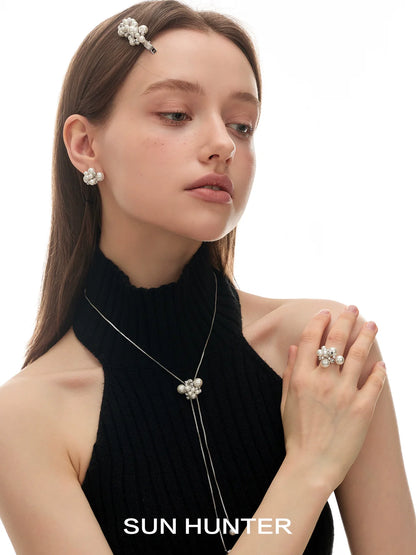 Model wearing SUN HUNTER elegant pearl statement ring with matching pearl accessories