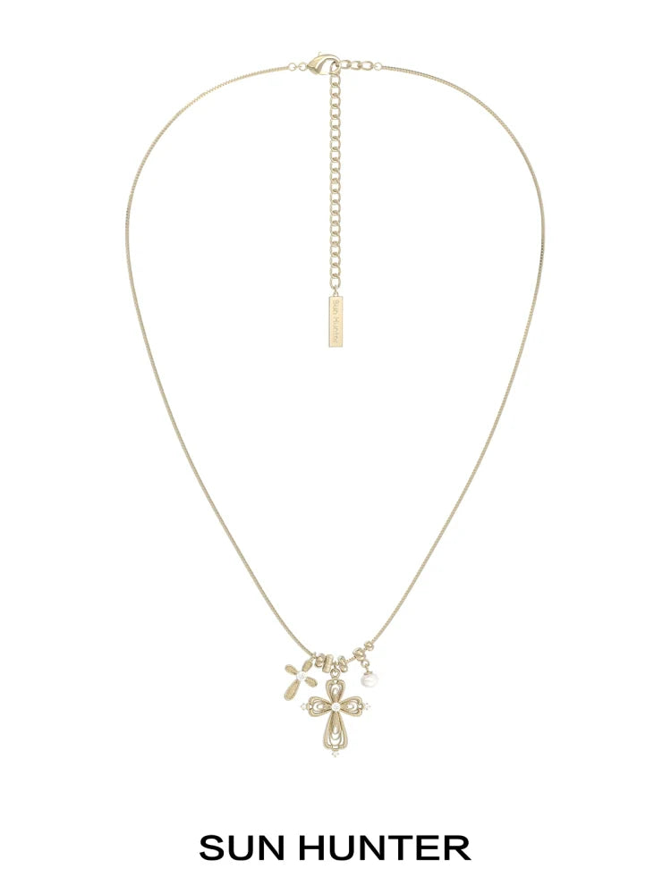 Sun Hunter faith charm necklace featuring a delicate cross and charm design in gold