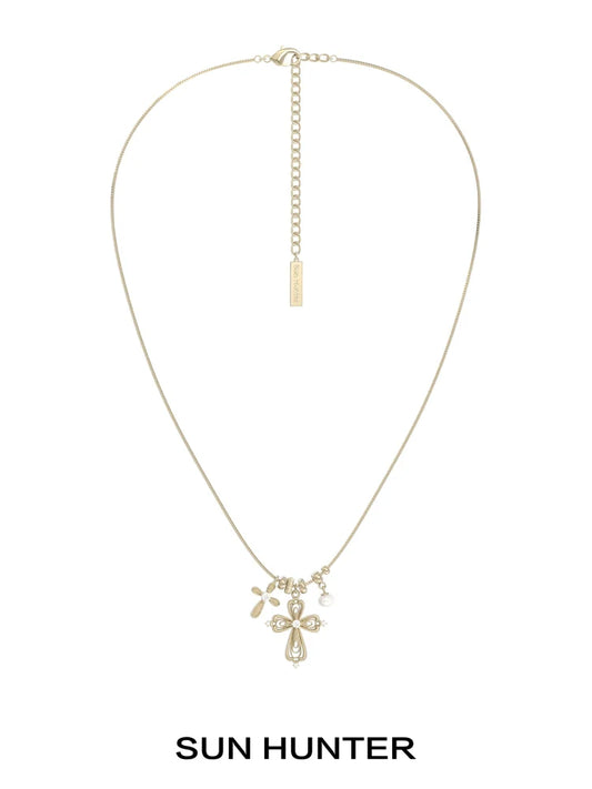 Sun Hunter faith charm necklace featuring a delicate cross and charm design in gold