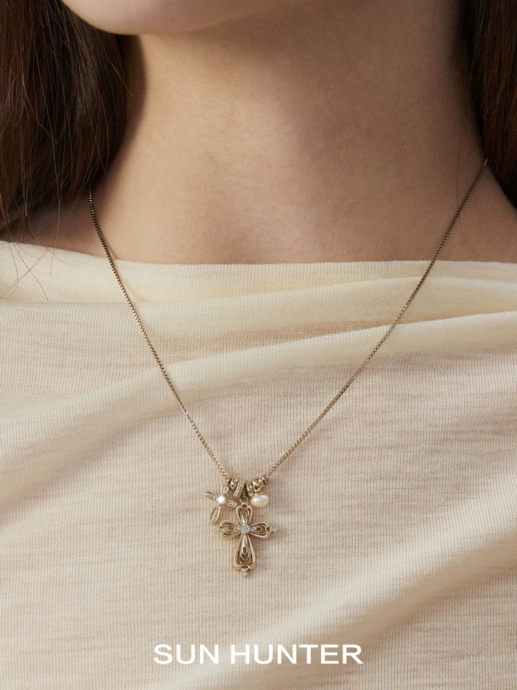 SUN HUNTER faith charm necklace featuring a delicate cross design on a gold chain