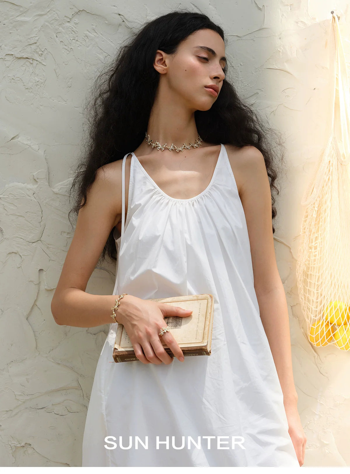 Model wearing a white dress with a SUN HUNTER French retro butterfly ring as a stylish accessory