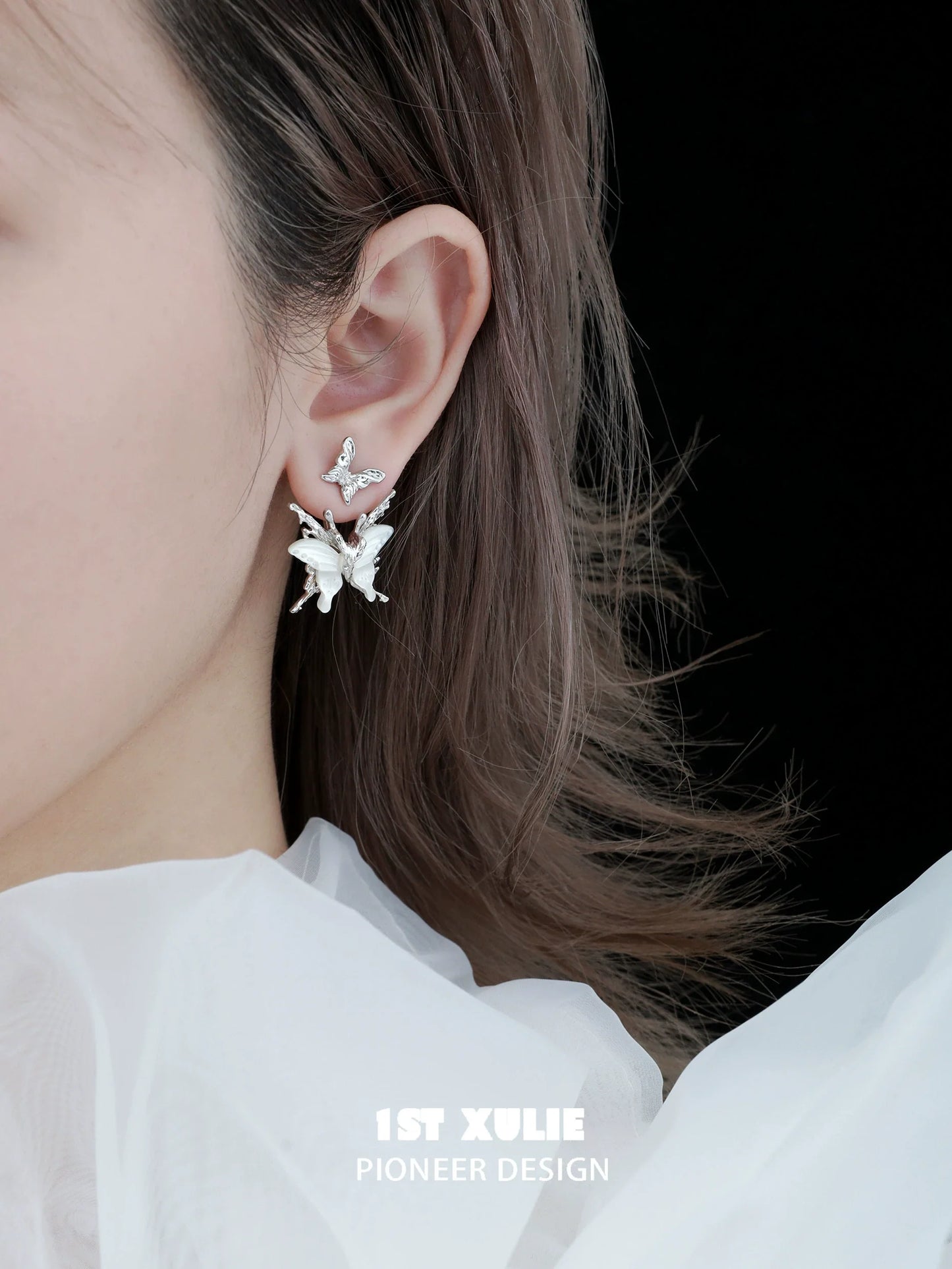 Futuristic butterfly earrings in silver design showcasing intricate details worn by a model