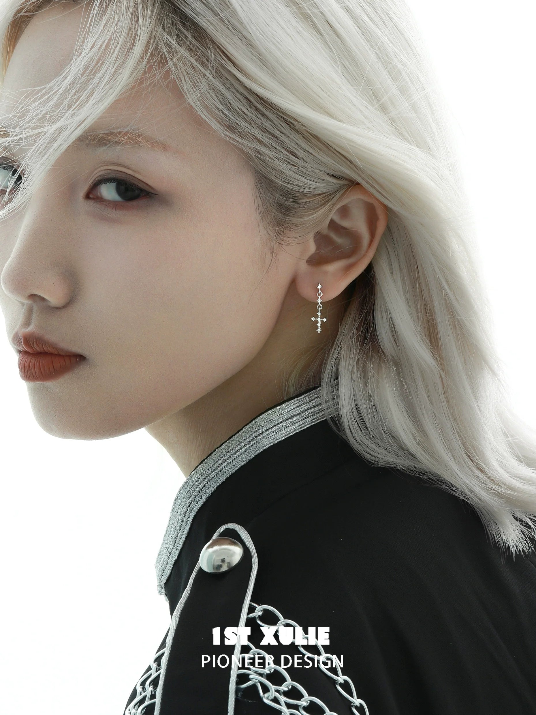 Model wearing 1STXULIE futuristic cross chain earrings, featuring a stylish design and silver accents