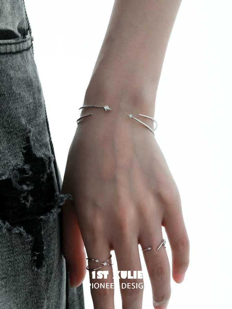 Stylish hand wearing a futuristic silver bracelet alongside matching rings for contemporary fashion.