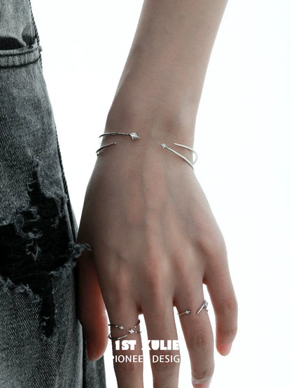 Stylish hand wearing a futuristic silver bracelet alongside matching rings for contemporary fashion.