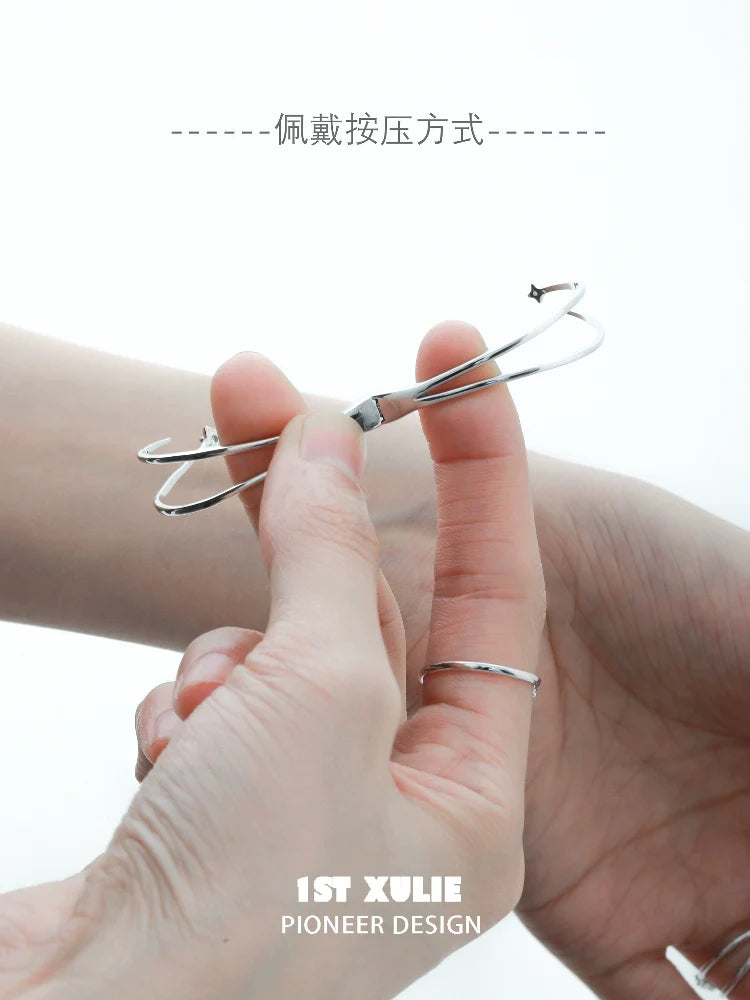 Futuristic silver bracelet being adjusted on a wrist for a sleek look