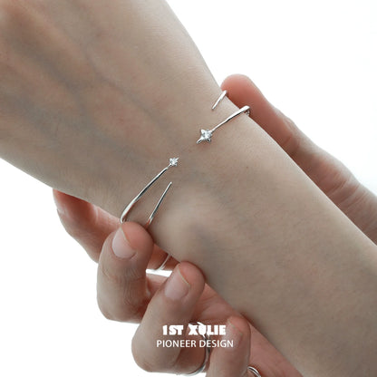 Minimalist design of a futuristic silver bracelet with delicate star accents on a wrist