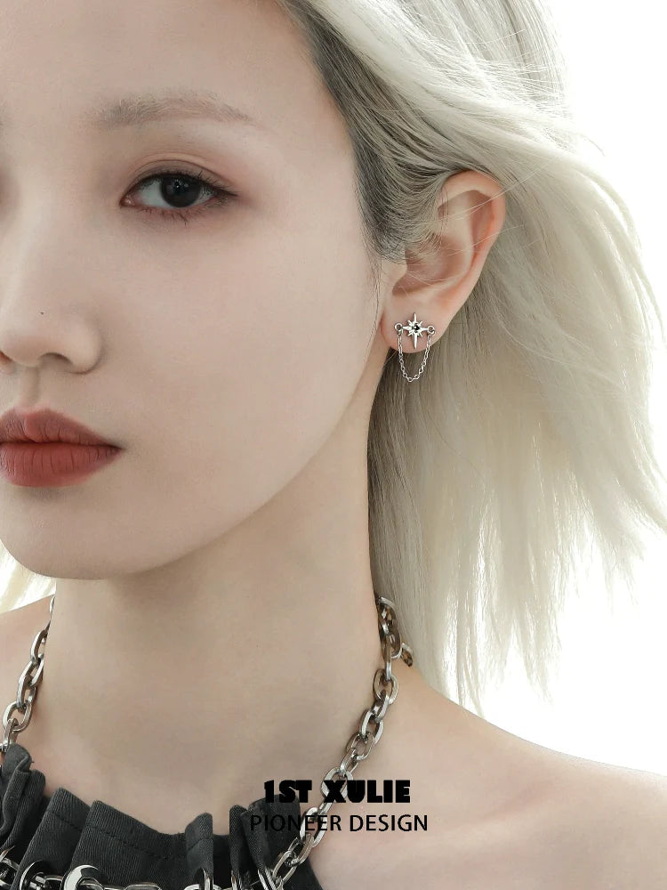 Futuristic star chain earrings displayed on a model with silver jewelry and styled hair