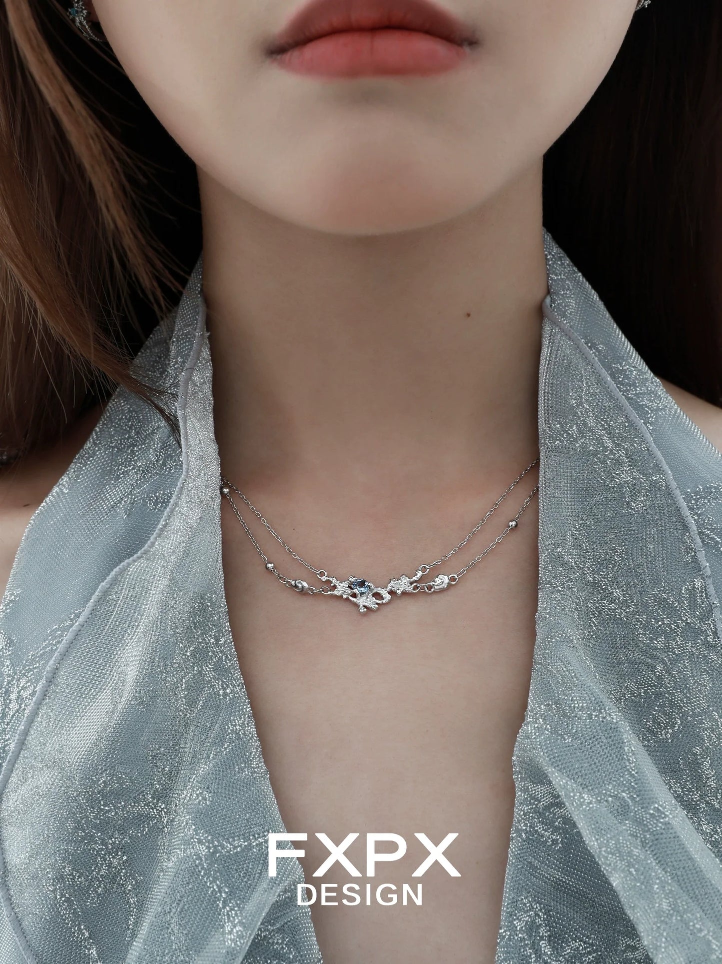 Elegant blue crystal necklace layered with delicate silver chains for a stunning look