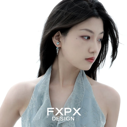 Elegant blue glacier earrings showcased on a model with a soft hairstyle and stylish outfit