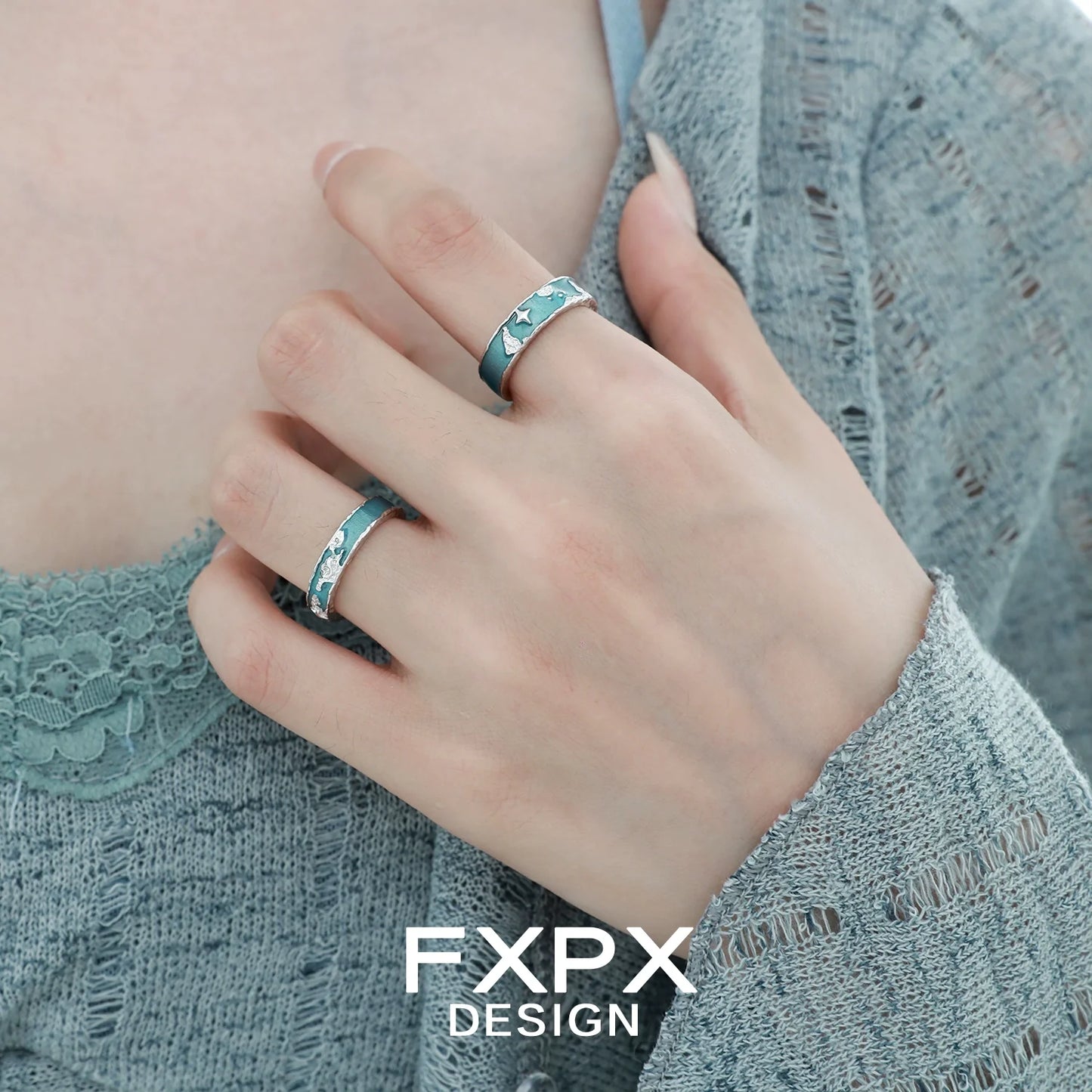 Stylish FXPX blue planet puzzle ring worn on fingers, featuring a unique design with celestial elements