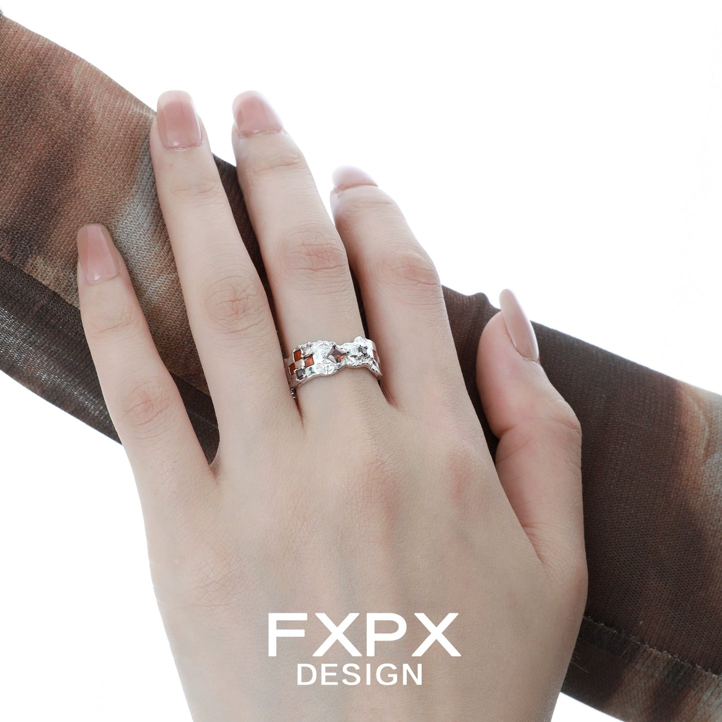 Elegant brown checkerboard silver ring displayed on a hand with a stylish scarf