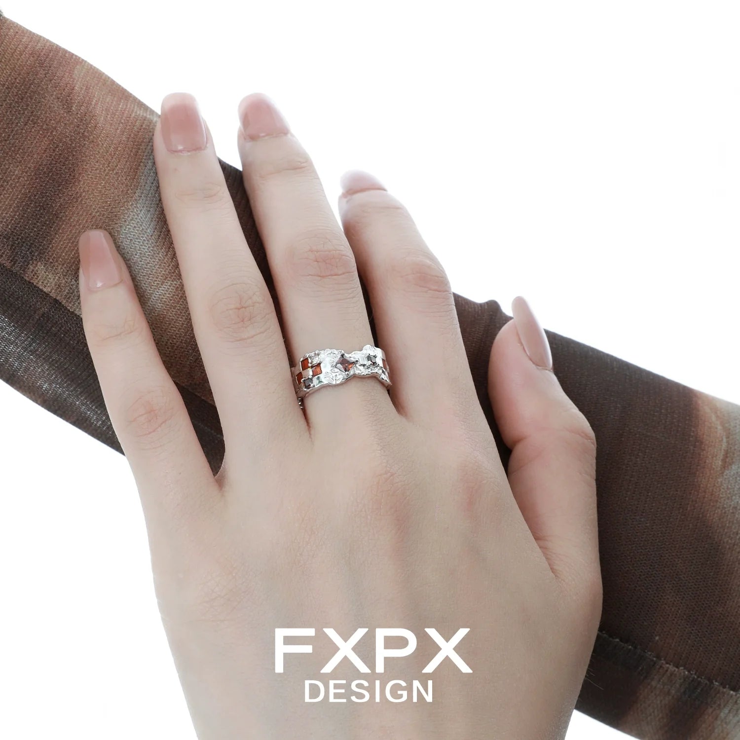 Elegant brown checkerboard silver ring displayed on a hand with a stylish scarf