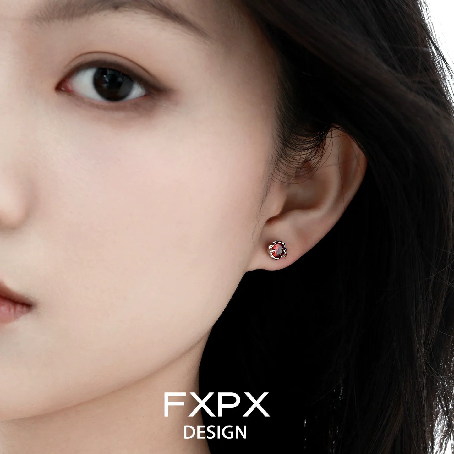 Close-up of colorful zircon stud earrings worn by a model for a stylish look
