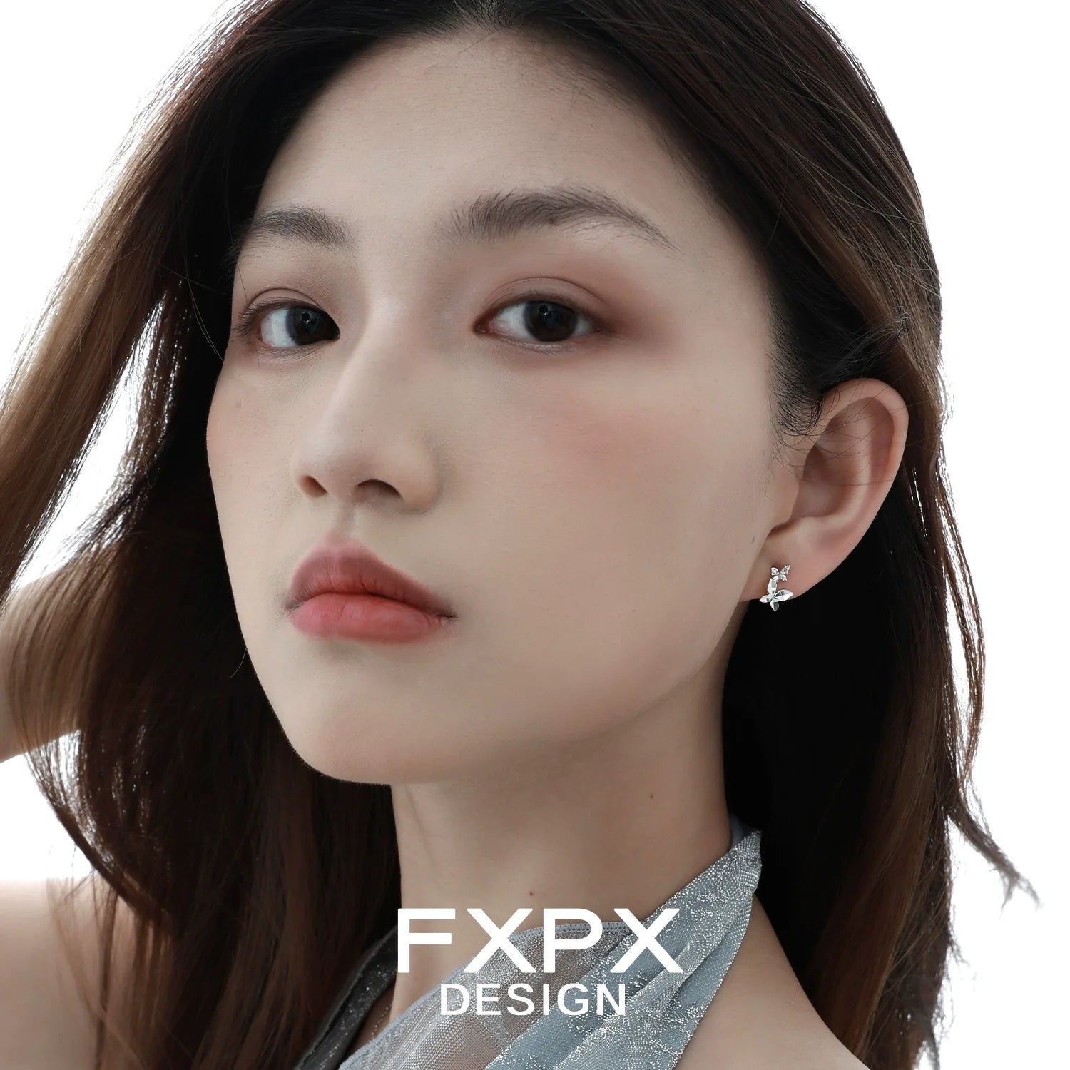 Elegant mirror butterfly silver earrings showcased on a model's ear with soft lighting