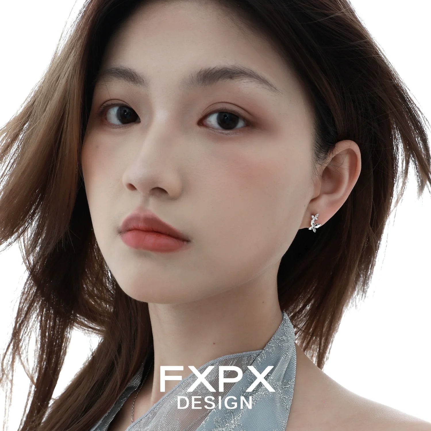 Mirror butterfly silver earrings by FXPX displayed on a model with flowing hair