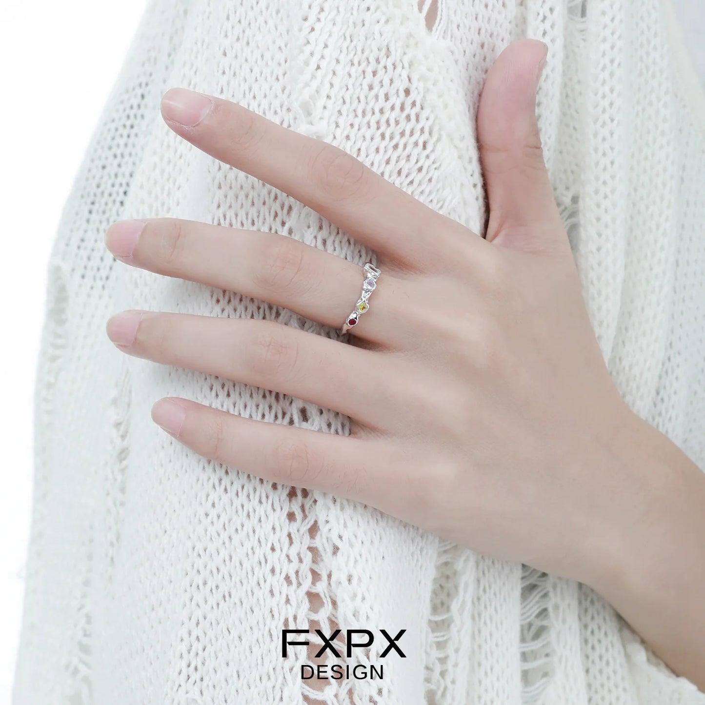 Dopamine colored zircon ring showcased on a model's hand with a stylish outfit