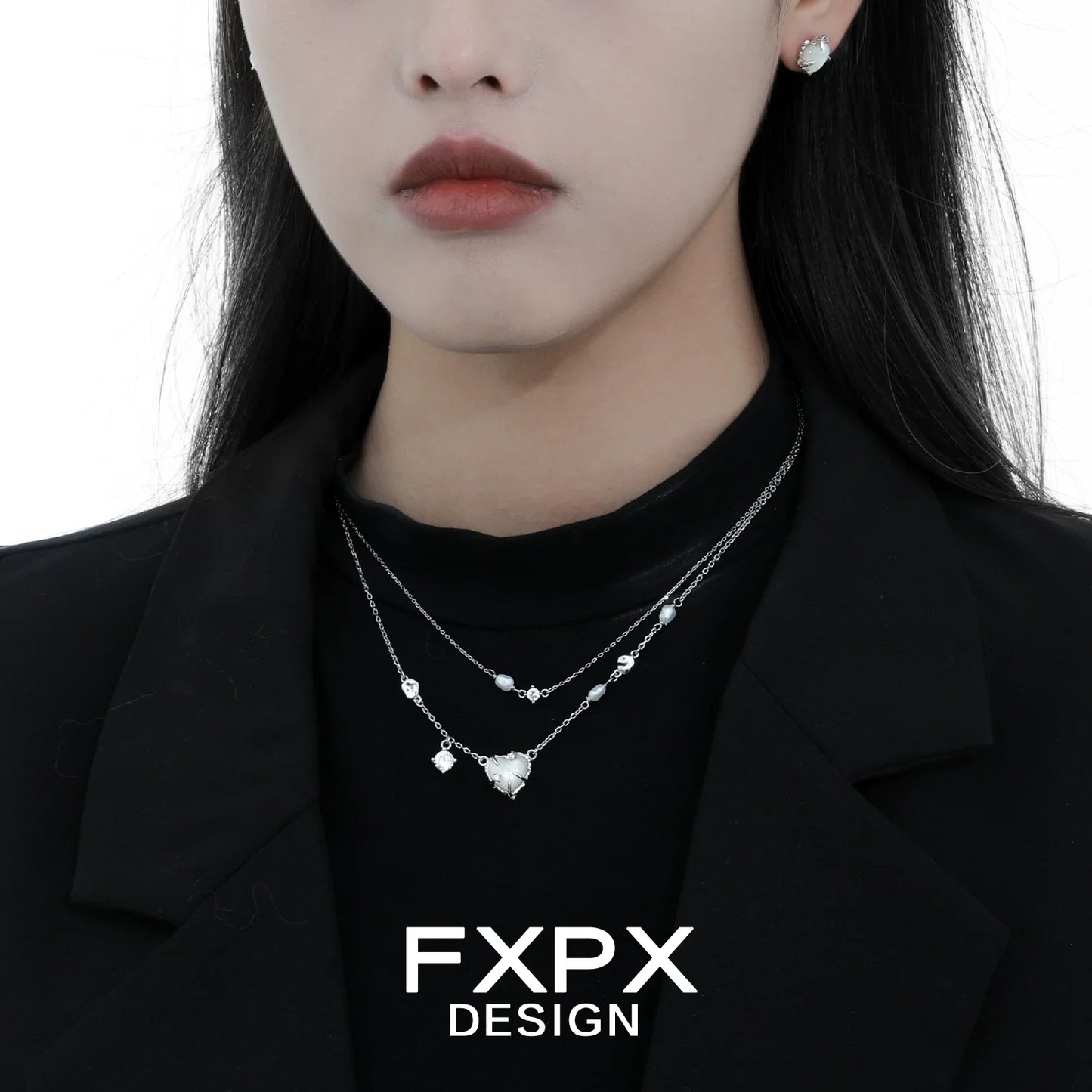 Stylish model wearing double layer silver love necklace with delicate charms and matching earrings