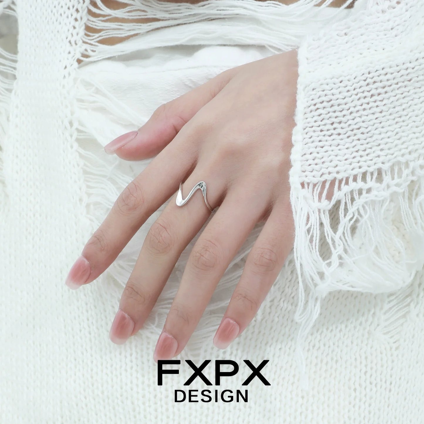 Elegant flowing silver ring design showcased on a hand with delicate fingers