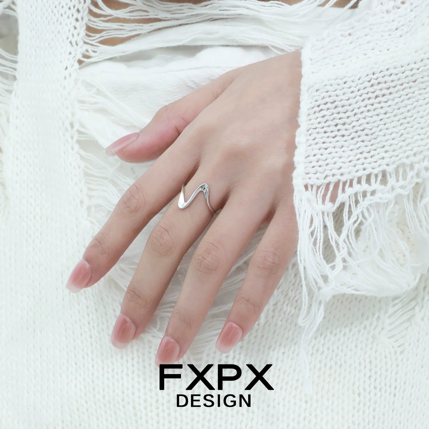 Elegant flowing silver ring design showcased on a hand with delicate fingers