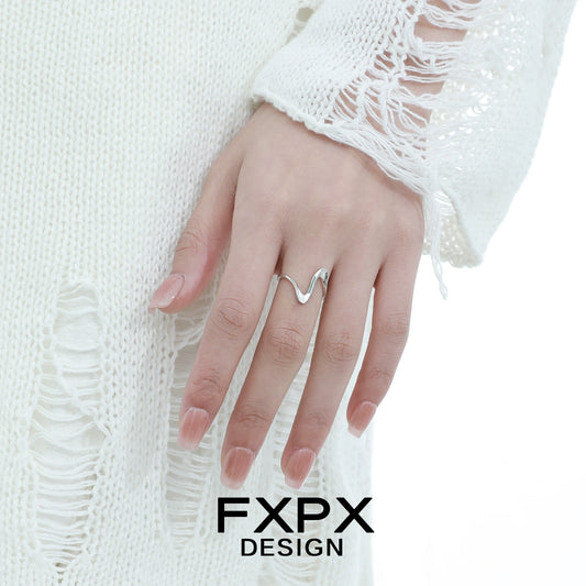 Elegant hand wearing a flowing silver ring from FXPX, showcasing a unique wavy design