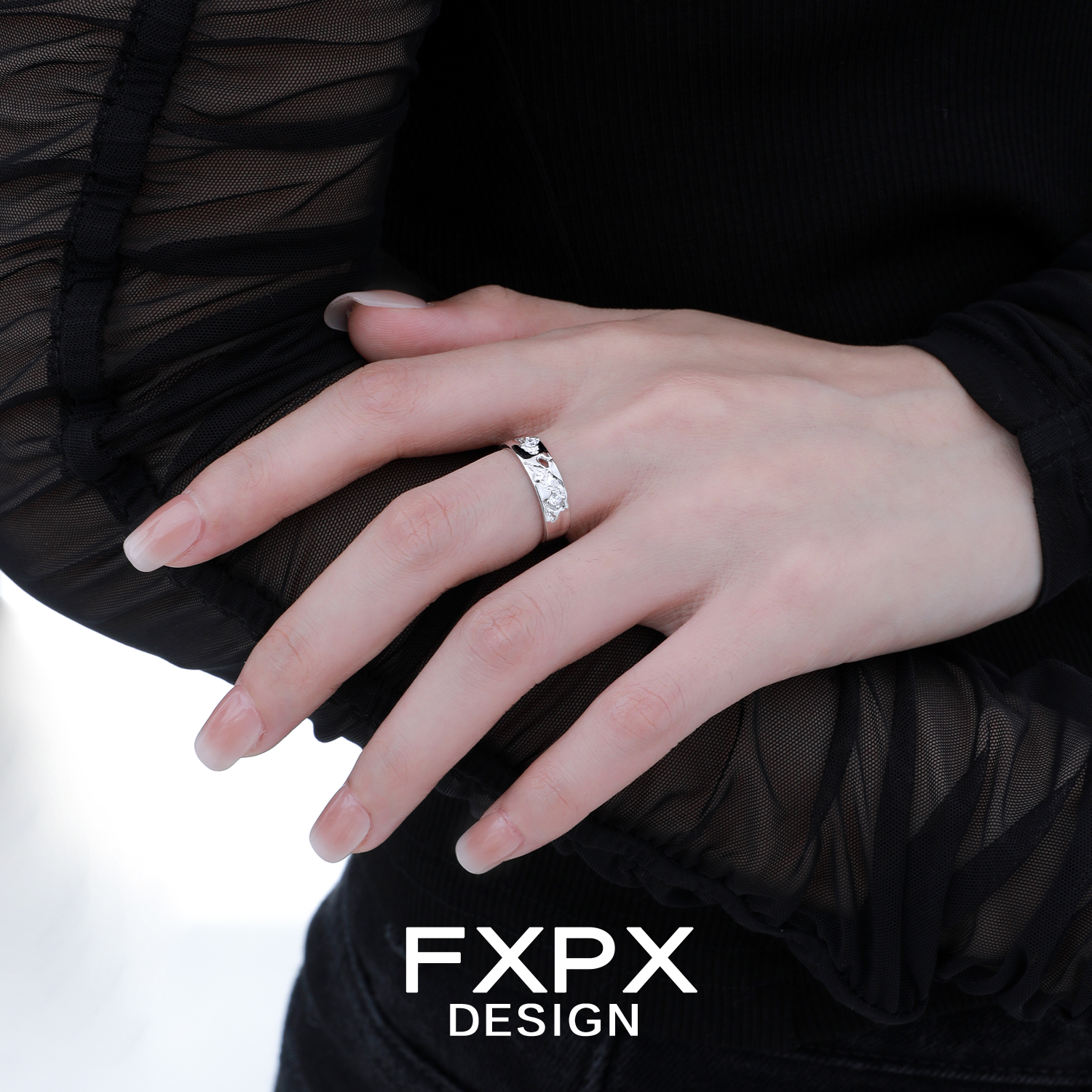 Elegant FXPX fractured texture silver ring displayed on a model's hand with stylish attire