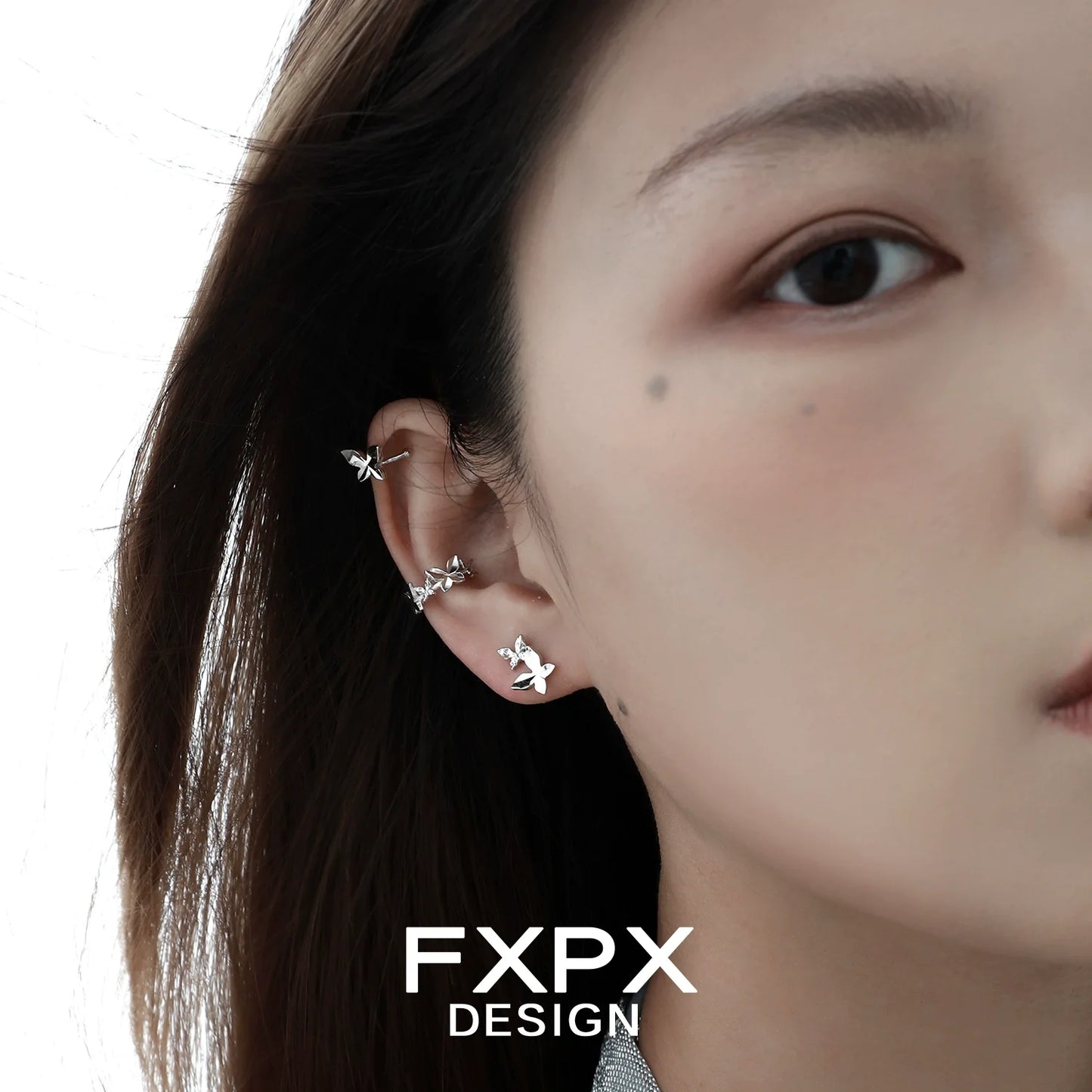 Stylish FXPX futuristic butterfly ear cuff design worn on a model's ear for a trendy look