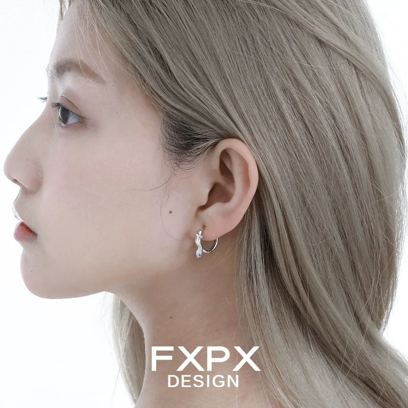 Glacier blue snake earrings in silver, stylishly worn on a model's ear for a chic look