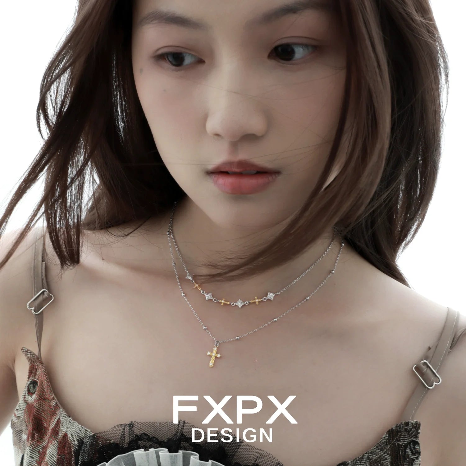 Elegant gold faith cross necklace paired with layered silver necklaces for a stylish look