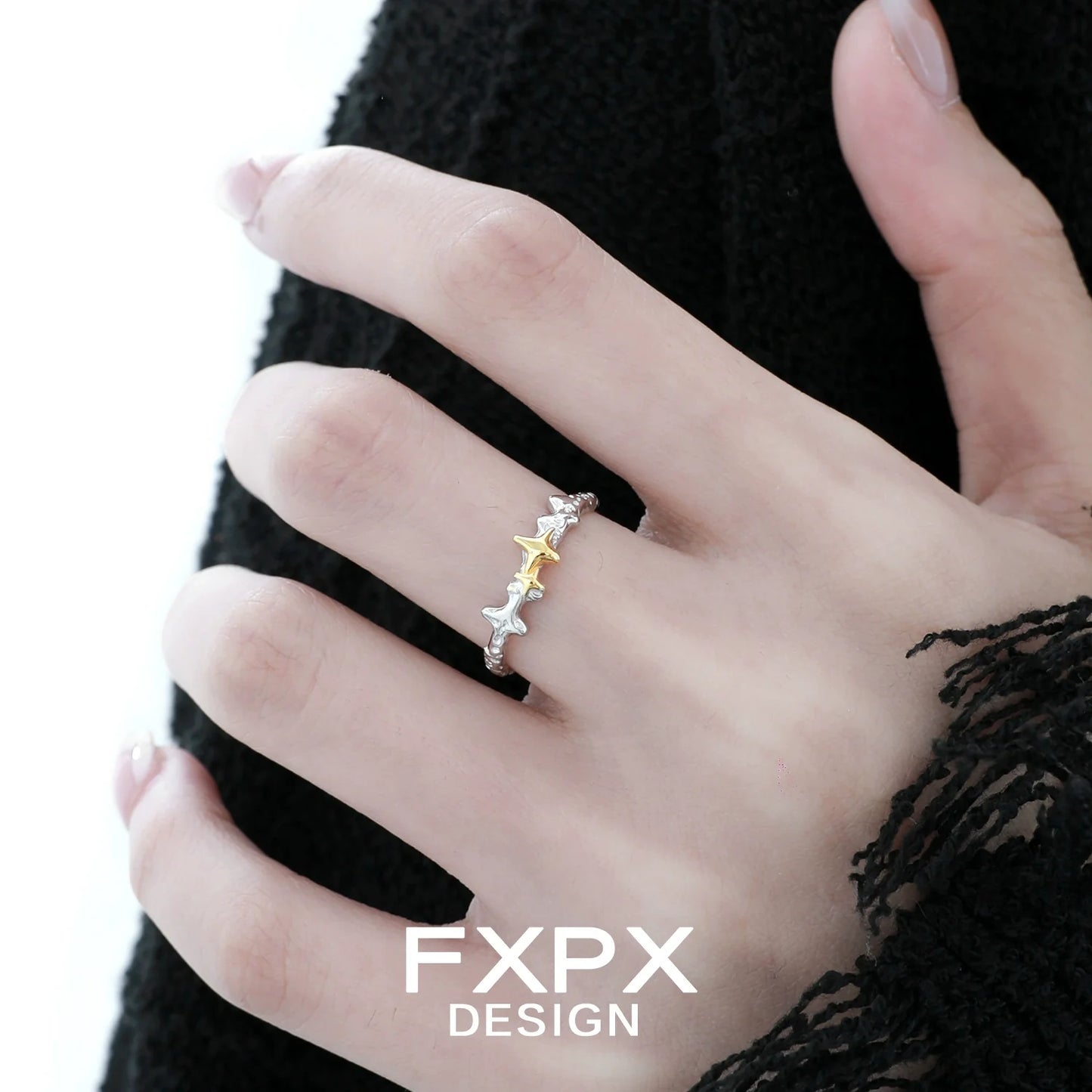 Elegant FXPX gold star ring on model's hand showcasing a modern design and shimmering accents