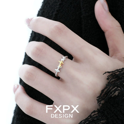 Elegant FXPX gold star ring on model's hand showcasing a modern design and shimmering accents