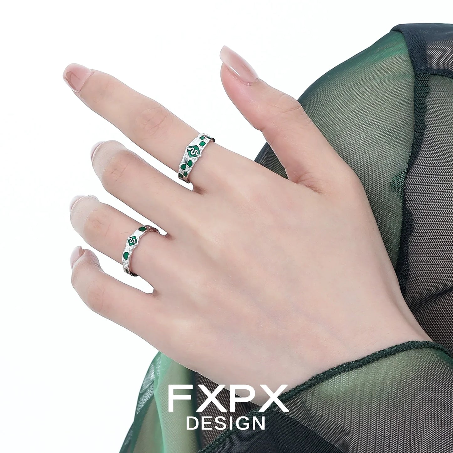 FXPX green snake ring featuring intricate design and green gemstones worn on a delicate hand