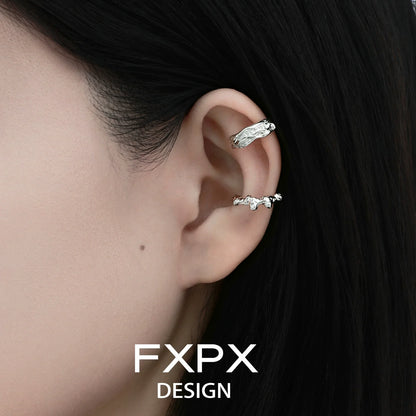 Irregular silver earrings displayed on a model's ear showcasing unique textured design by FXPX