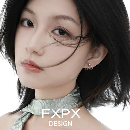 Elegant meteor silver earrings designed by FXPX, worn by a model with flowing hair