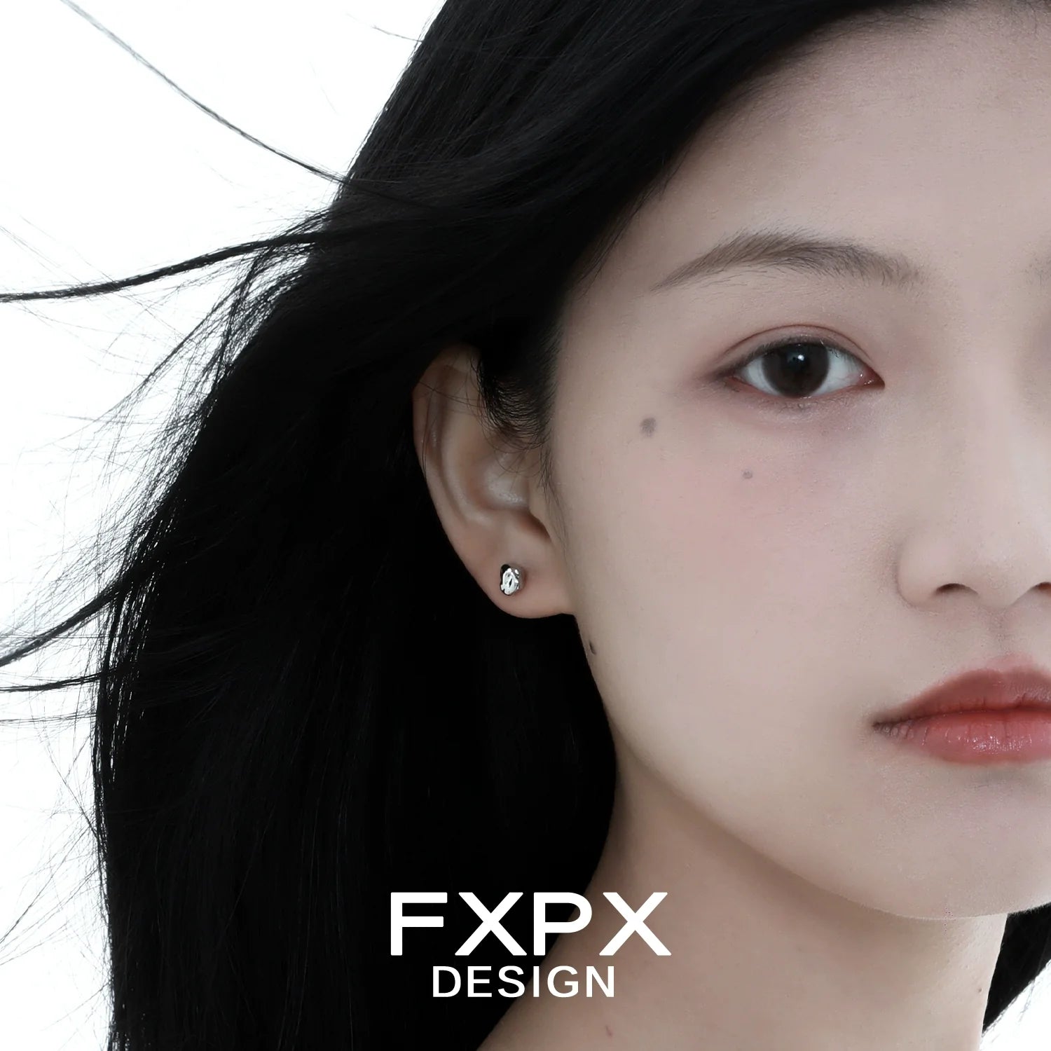 Stylish FXPX meteorite stud earrings showcasing a sleek and modern design on a model's ear