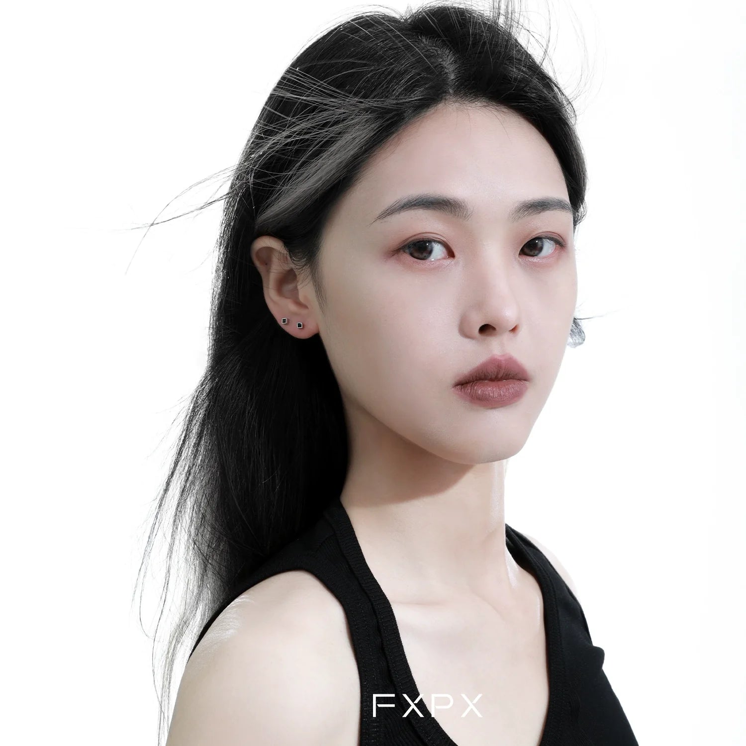 Elegant minimalist black and white earrings showcased on a model with flowing black hair