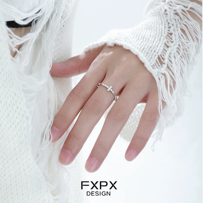Delicate minimalist cross silver ring displayed on a hand with soft, stylish sweater