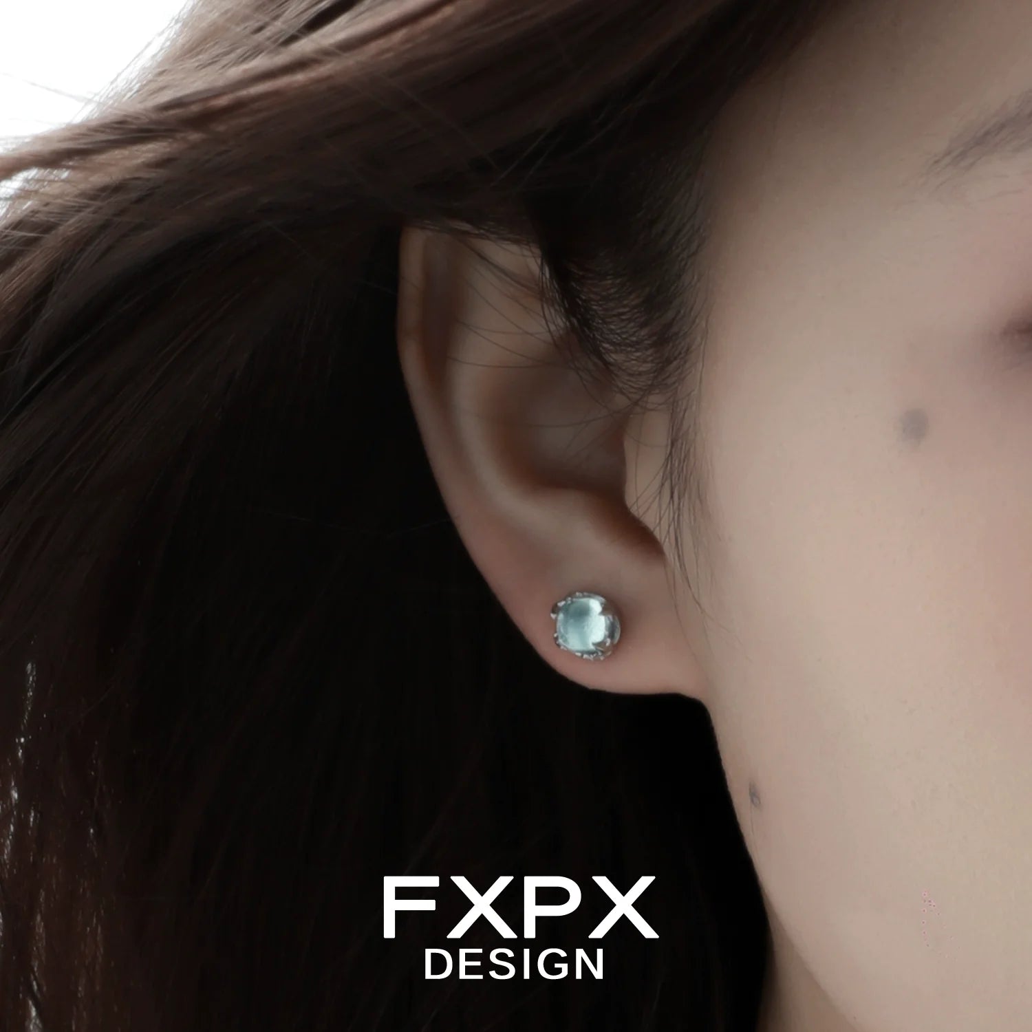 FXPX minimalist glacier earrings featured on a model's ear with a soft, elegant design