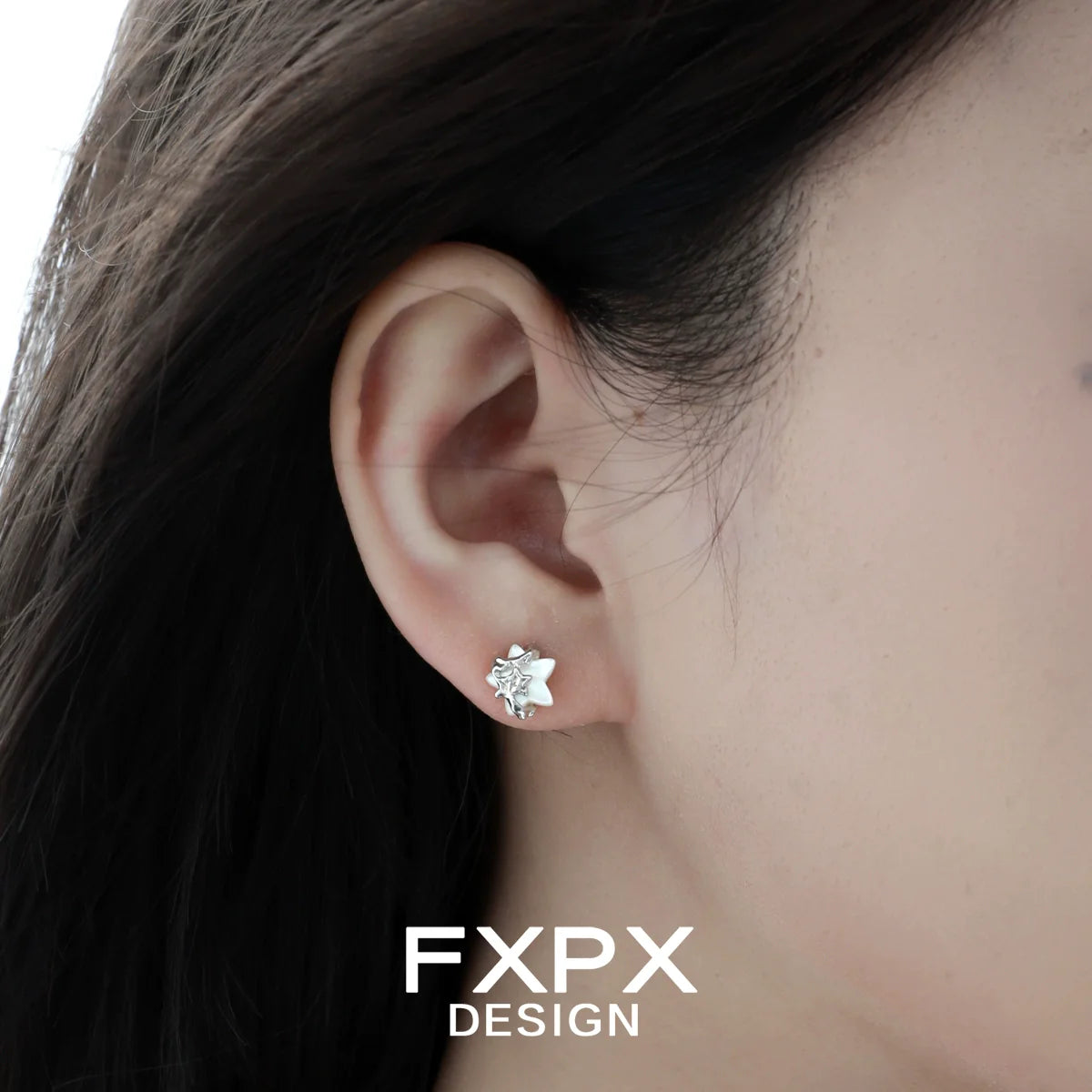 Minimalist star shell earrings designed by FXPX showcased on a model's ear
