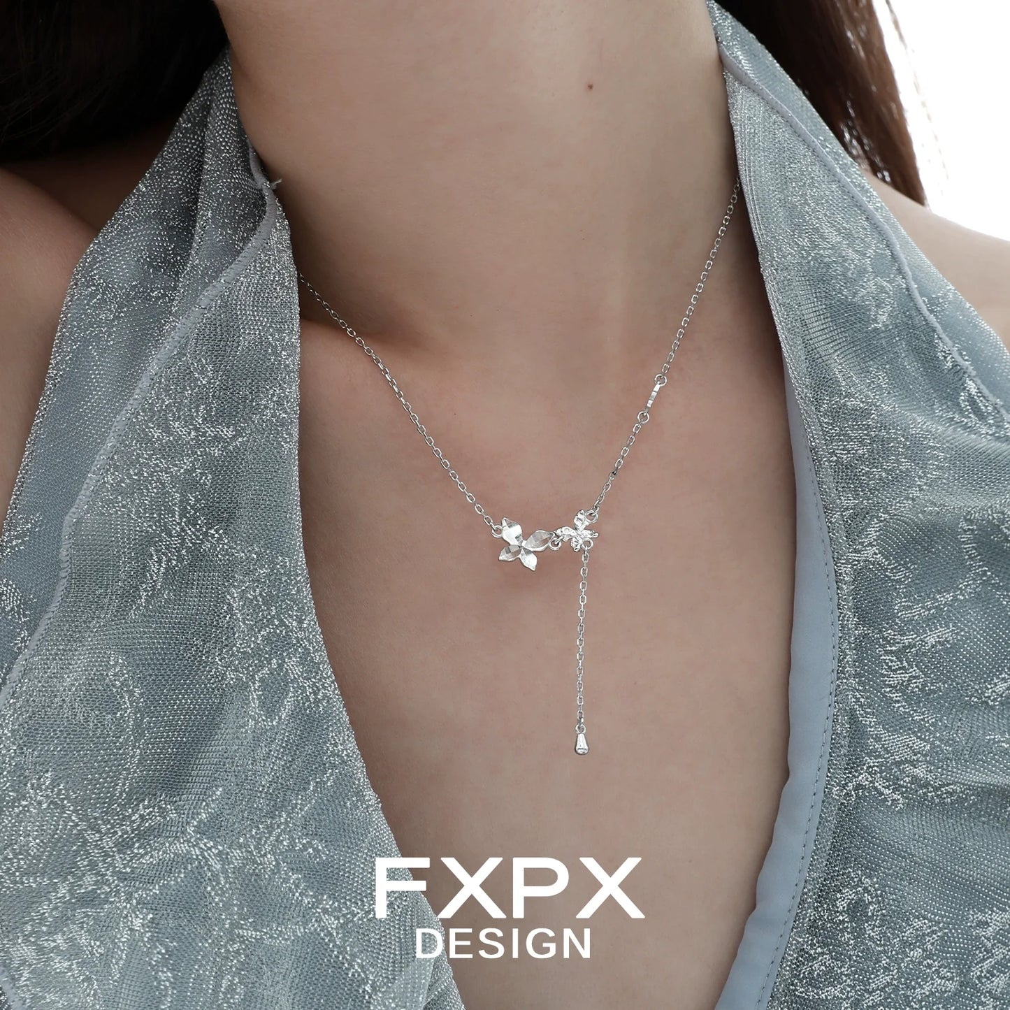 Elegant FXPX mirror butterfly pendant necklace displayed on a model's neck in soft lighting