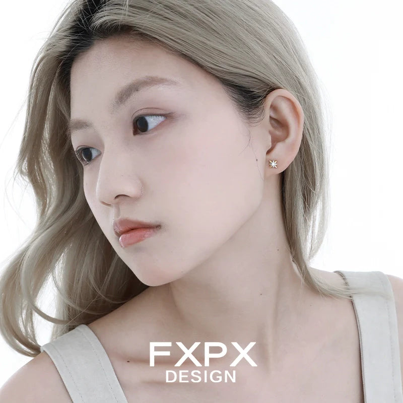 Elegant mystic gold star earrings showcased on model with long hair and neutral outfit