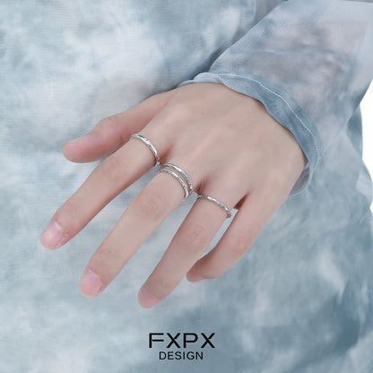 Three silver rings worn on a hand featuring the ocean breeze ring design for a stylish look